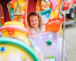 young child smiling while on a fairground ride