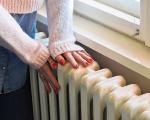 person placing their hands on top of a radiator
