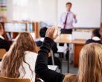 pupils putting hand up in a classroom