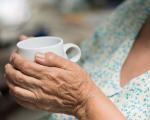 hands of an older person holding a mug