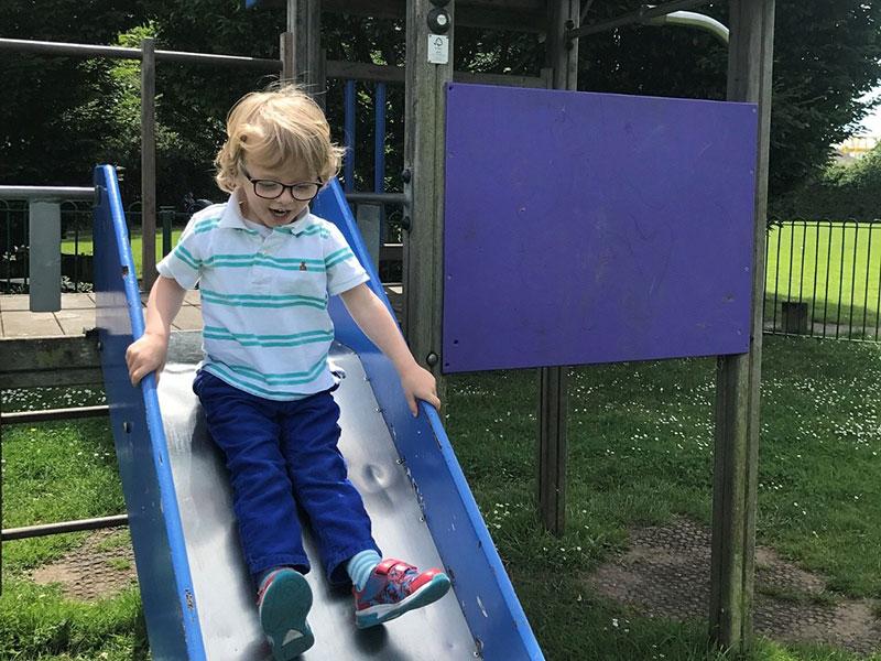 young child going down a metal slide