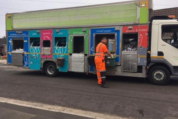 bin man wearing orange overalls stood next to a North Somerset recycling lorry
